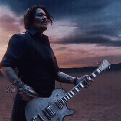 A Man Playing A Guitar In A Desert With A Twitter Logo On The Bottom Right GIF