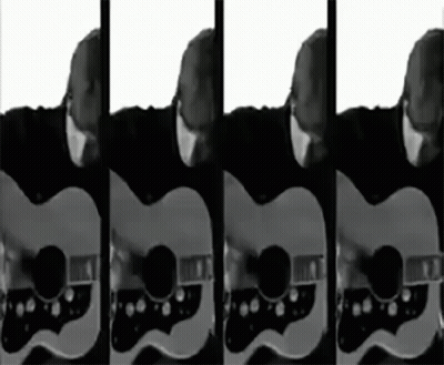 A Man Playing A Guitar In Black And White GIF