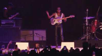 A Man Playing A Guitar In Front Of A Crowd With The Words Coachella Visible GIF