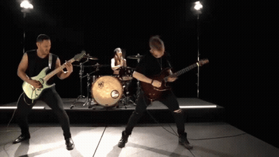 A Man Playing A Guitar In Front Of A Drum Set With A Yamaha Logo On It GIF