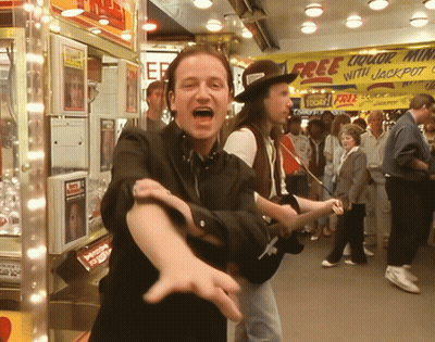 A Man Playing A Guitar In Front Of A Free Liquor With Jackpot Sign GIF