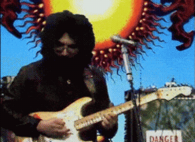 A Man Playing A Guitar In Front Of A Sign That Reads Danger GIF