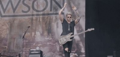 A Man Playing A Guitar On A Stage In Front Of A Sign That Says Wson GIF