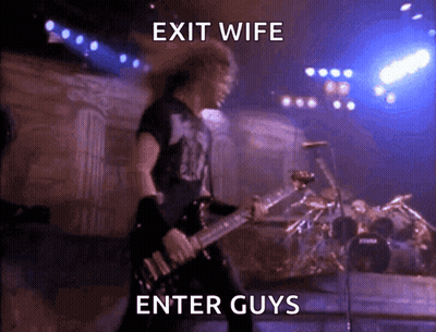 A Man Playing A Guitar On A Stage With The Words Exit Wife Enter Guys Below Him GIF