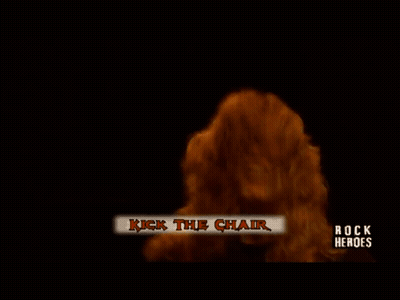 A Man Playing A Guitar On A Stage With The Words Rock Heroes On The Bottom Left GIF