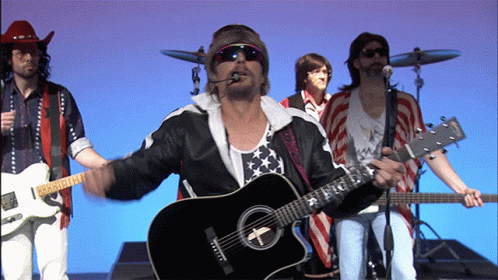 A Man Playing A Guitar That Has The Letter T On It GIF
