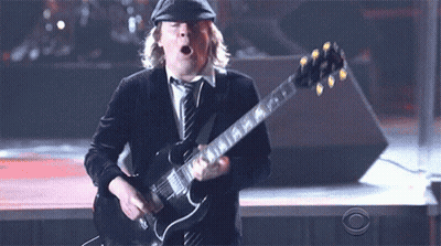 A Man Playing A Guitar With A Cbs Logo Behind Him GIF