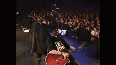 A Man Playing A Guitar With A Shirt That Says ' Fuck Prison ' On It GIF