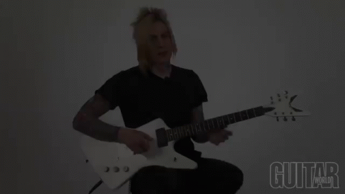A Man Playing A Guitar With The Words Guitar World Below Him GIF