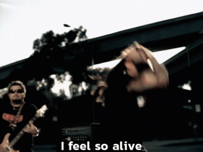 A Man Playing A Guitar With The Words " I Feel So Alive " Below Him GIF
