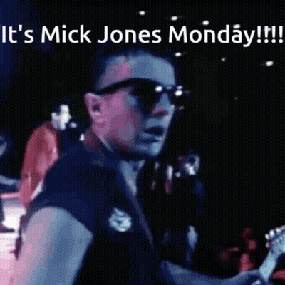 A Man Playing A Guitar With The Words It 'S Mick Jones Monday Written Above Him GIF