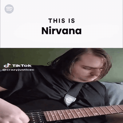 A Man Playing A Guitar With The Words " This Is Nirvana " Behind Him GIF