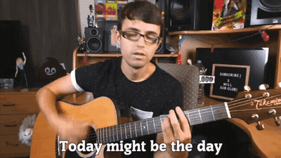 A Man Playing A Guitar With The Words " Today Might Be The Day " Behind Him GIF