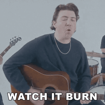 A Man Playing A Guitar With The Words " Watch It Burn " Behind Him GIF
