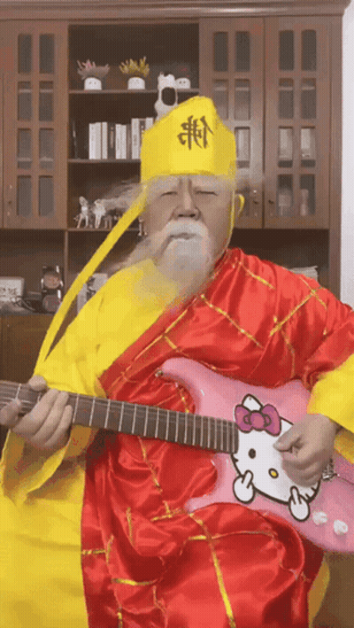 A Man Playing A Pink Hello Kitty Guitar GIF