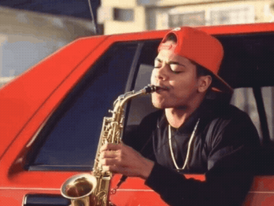 A Man Playing A Saxophone In A Red Car GIF