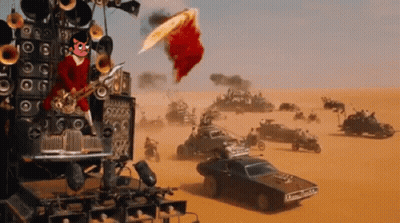 A Man Playing A Saxophone In The Middle Of A Desert With Cars In The Background GIF