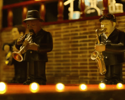 A Man Playing A Trumpet And A Man Playing A Saxophone Are On A Stage GIF