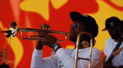 A Man Playing A Trumpet In Front Of A Red And Yellow Background With The Word Cancella On The Bottom GIF
