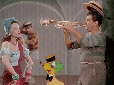 A Man Playing A Trumpet Next To A Woman GIF