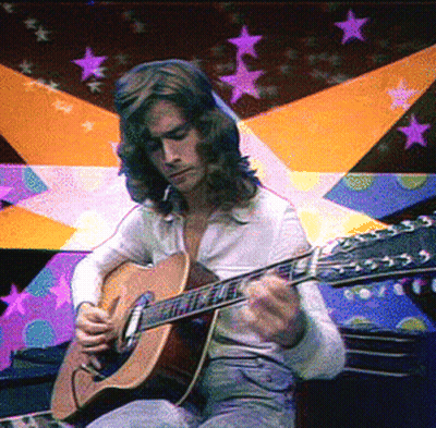 A Man Playing An Acoustic Guitar In Front Of A Colorful Background GIF
