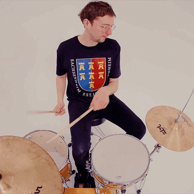 a man playing drums wearing a shirt that says sachsen-vp