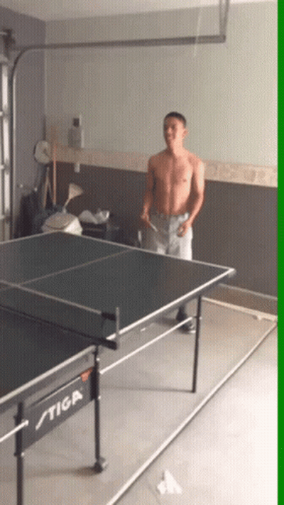 A Man Playing Ping Pong On A Stiga Table In A Garage GIF