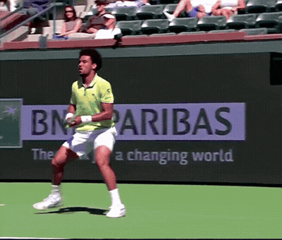 A Man Playing Tennis In Front Of A Bn Paribas Ad GIF