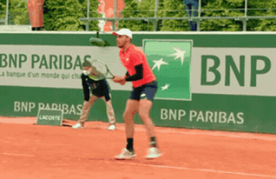 A Man Playing Tennis In Front Of A Bnp Banner GIF