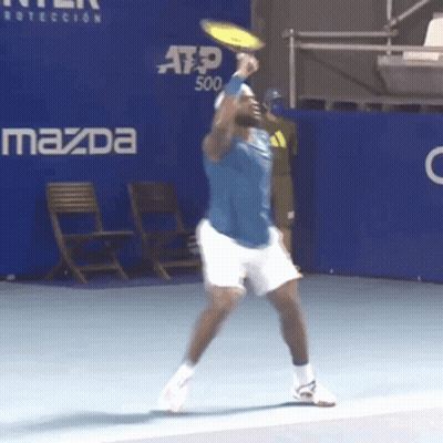 A Man Playing Tennis In Front Of A Mazda Ad GIF