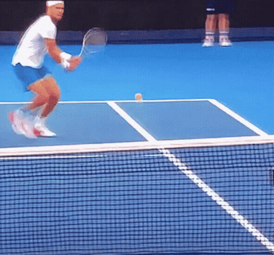 A Man Playing Tennis On A Blue Court With A Yellow Ball On The Court GIF