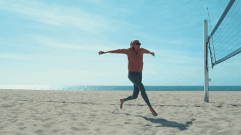 A Man Playing Volleyball On A Beach With A Banner That Says ' Volley ' On It GIF
