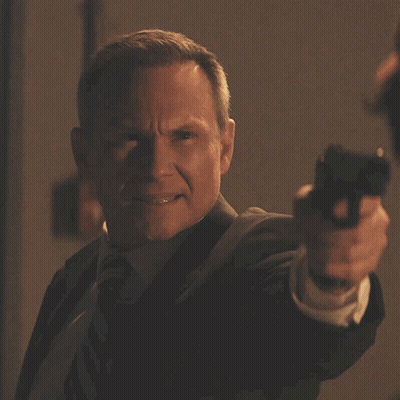 a man pointing a gun with the words " what are you talking about " behind him