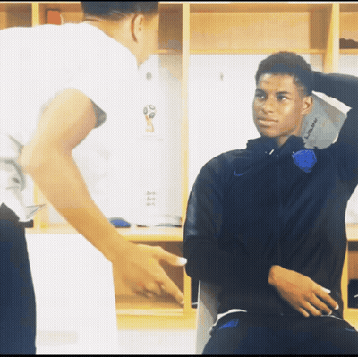 A Man Pointing At Another Man In A Locker Room That Says ' England ' On The Wall GIF