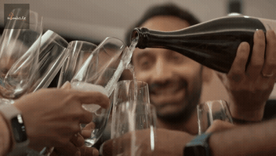 A Man Pouring A Bottle Of Wine Into A Glass GIF