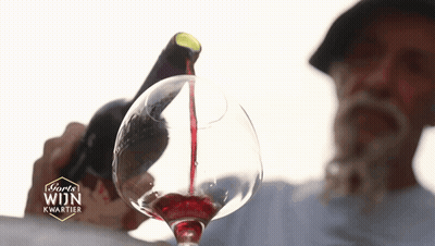 A Man Pouring Red Wine Into A Glass With The Word Wijn On The Bottom Right GIF