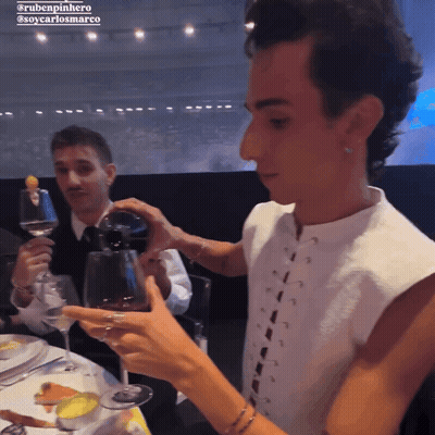A Man Pouring Wine Into A Glass With The Name Rubenpinheiro On The Bottom Right GIF