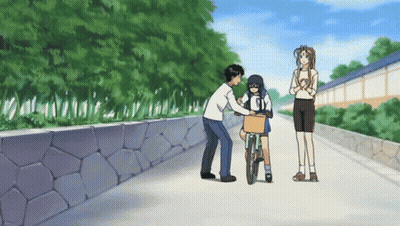 A Man Pushes A Girl On A Bicycle While A Woman Looks On GIF