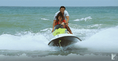 A Man Pushes A Woman On A Jet Ski In The Ocean GIF