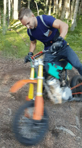 A Man Riding A Dirt Bike In The Woods GIF