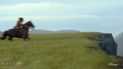 A Man Riding A Horse In A Field With A Disney Logo In The Corner GIF