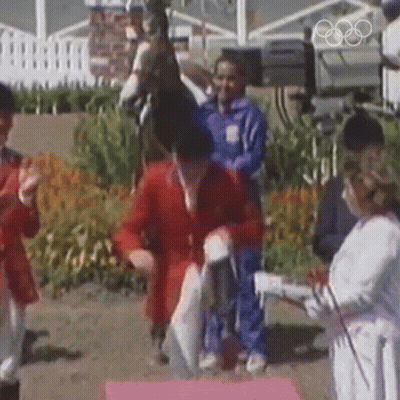 A Man Riding A Horse Is Being Congratulated By A Woman GIF