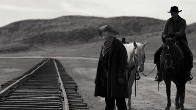 A Man Riding A Horse Next To A Woman On A Train Track GIF
