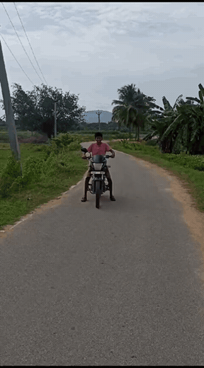 A Man Riding A Motorcycle Down A Dirt Road GIF