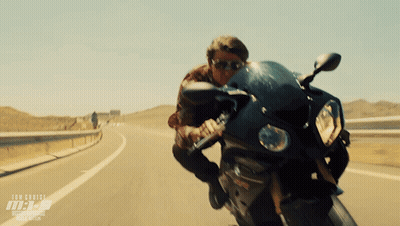A Man Riding A Motorcycle On A Highway With The Word Tom Cruise On The Bottom Right GIF