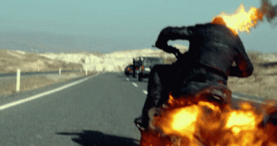 A Man Riding A Motorcycle With Flames Coming Out Of The Back GIF