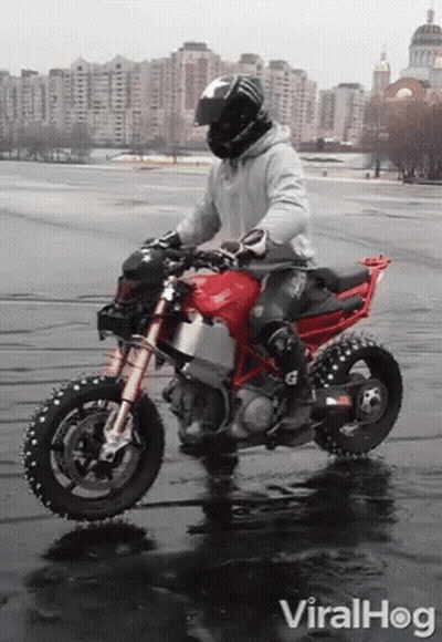 A Man Riding A Red Ducati Motorcycle In The Rain GIF