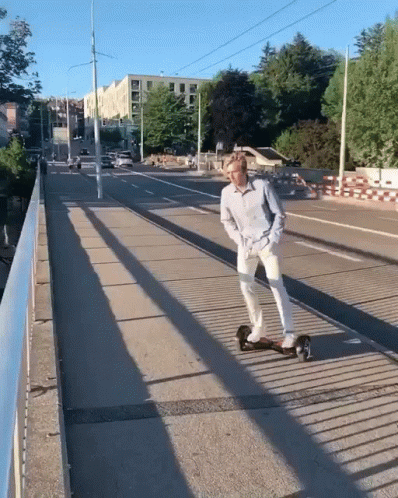 A Man Riding A Skateboard On A Bridge GIF