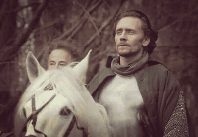 A Man Riding A White Horse With Another Man Standing Behind Him GIF