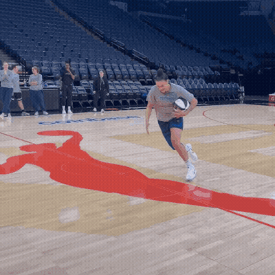 A Man Running With A Basketball On A Basketball Court With A Silhouette Of A Basketball Player On The Floor GIF